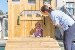 Toddler playing on wooden castle outside