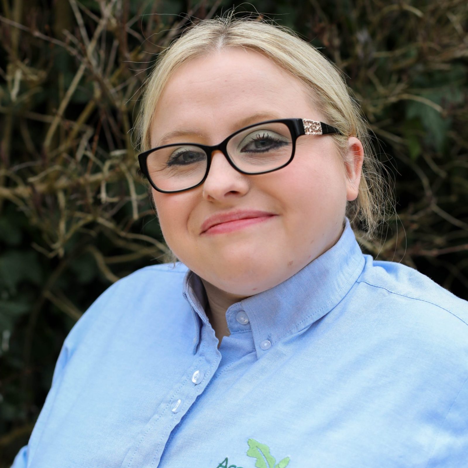 Acorns Nurseries A person in glasses and a light blue shirt featuring the 